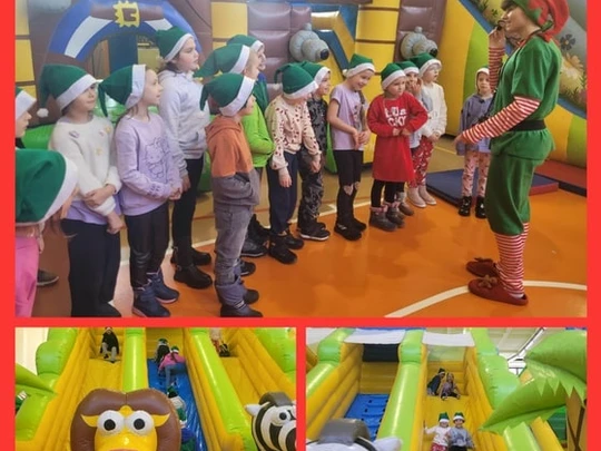 Uczniowie kl.1a stoją przed elfem oraz bawią się na dmuchańcach.