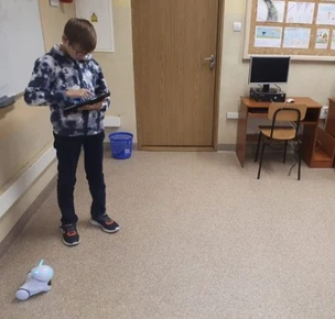 Zdjęcie przedstawia ucznia sterującego robotem Photon.