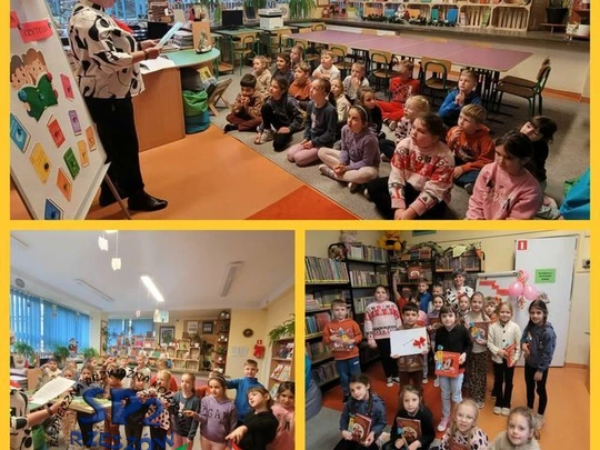 Uczniowie klasy 1a siedzą przed panią bibliotekarką i słuchają jej wypowiedzi oraz stoją z nią i składają przyrzeczenie.