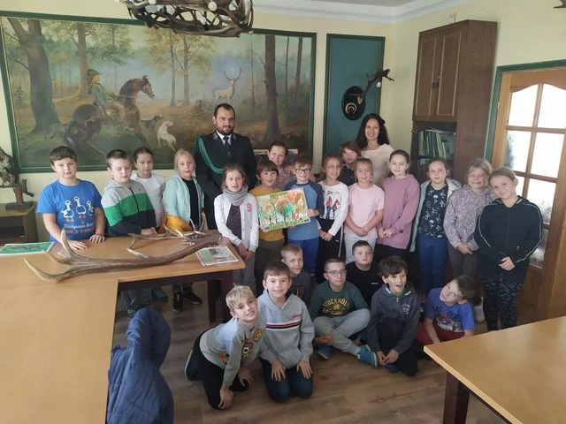 Uczniowie słuchają pogadanki w muzeum łowiectwa