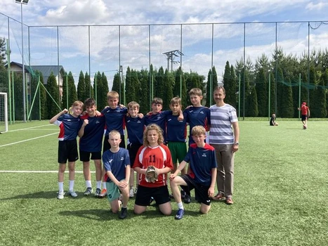 Drużyna piłkarzy z opiekunem - panem Jackiem Kuciem na boisku szkolnym.