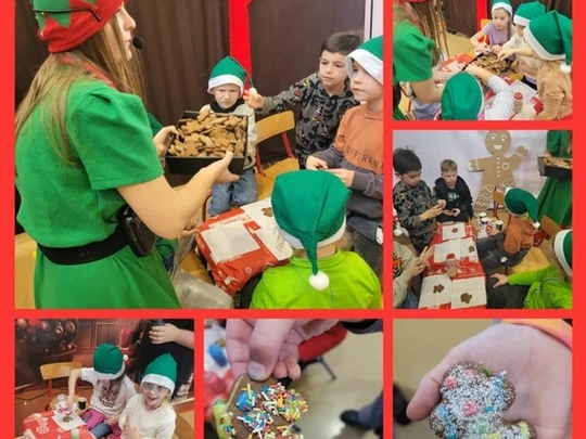 Elf rozdaje dzieciom pierniczki, kt&oacute;re one ozdabiają lukrem i słodką posypką.