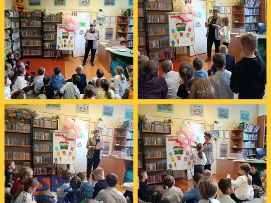 Uczniowie klasy 1b siedzą przed panią bibliotekarką i słuchają jej wypowiedzi.