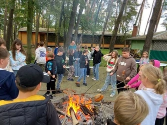 Uczniowie pieką kiełbaski nad ogniskiem po zabawie w aquaparku
