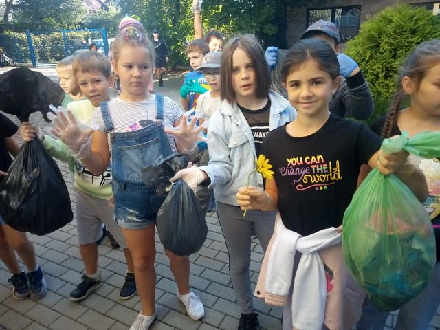 Na zdjęciu widoczni są uczniowie z reklamówkami, do których zbierali i segregowali odpady.