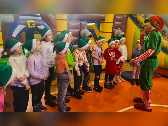 Dzieci stoją przed elfem.