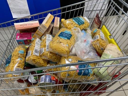 Wózek zakupowy pełny produktów ofiarowanych w akcji Caritas "Tak, Pomagam"