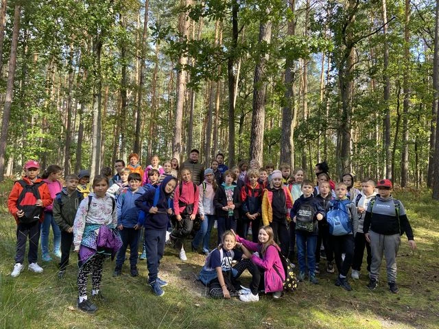 Na zdjęciu uczniowie na polanie leśnej.
